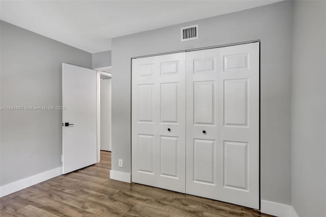 unfurnished bedroom featuring light hardwood / wood-style floors and a closet