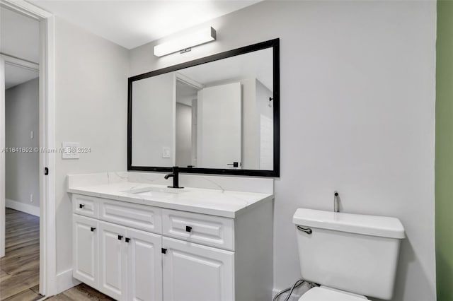 bathroom with vanity, toilet, and hardwood / wood-style flooring