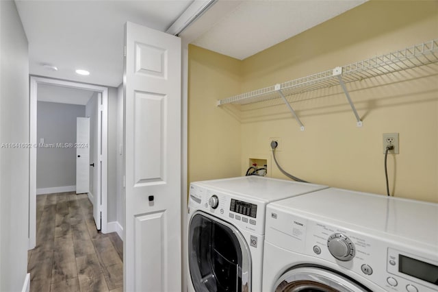 clothes washing area featuring hardwood / wood-style flooring and washer and dryer