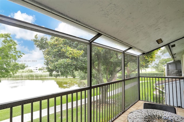 unfurnished sunroom featuring a water view