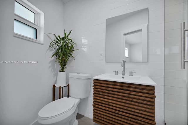 bathroom featuring tasteful backsplash, vanity, tile walls, and toilet