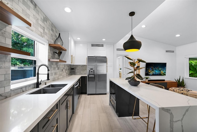 kitchen with sink, a healthy amount of sunlight, stainless steel appliances, and white cabinets