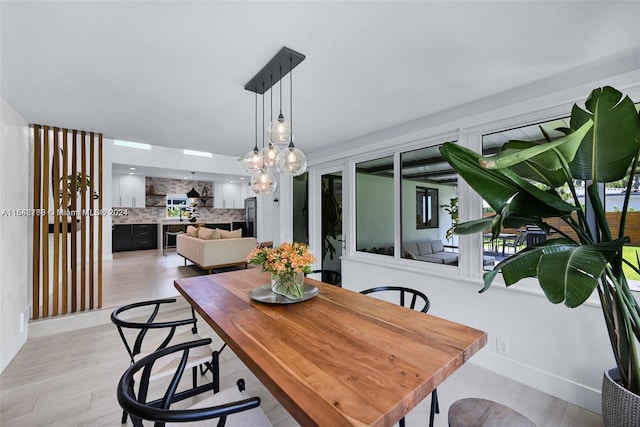 dining space featuring a notable chandelier and light hardwood / wood-style floors