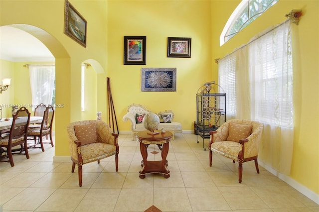 sitting room with a high ceiling and light tile patterned floors