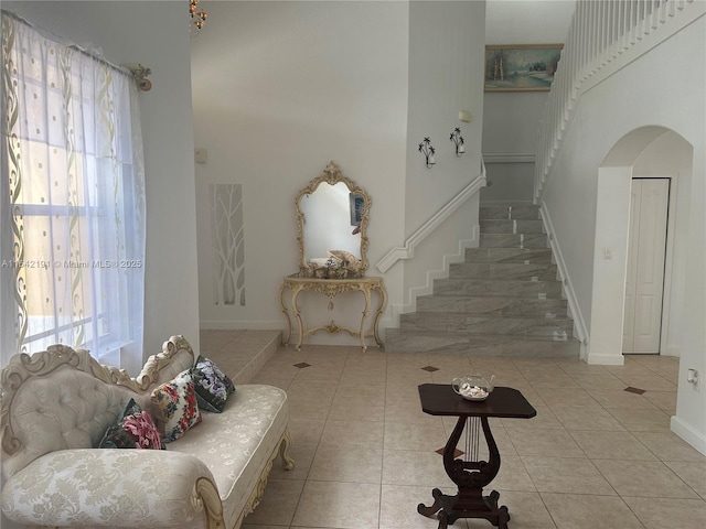 interior space with arched walkways, stairs, a wealth of natural light, and baseboards