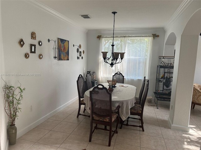 dining area with crown molding, a notable chandelier, and light tile patterned floors