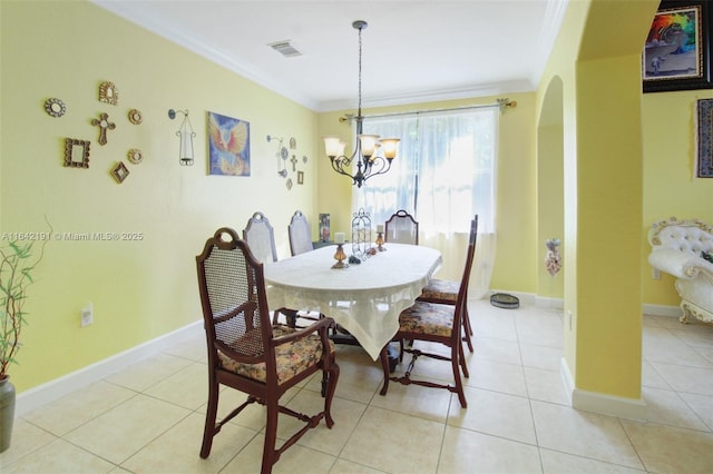 dining room with arched walkways, visible vents, an inviting chandelier, ornamental molding, and light tile patterned flooring