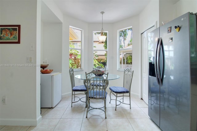 dining space with light tile patterned floors and baseboards