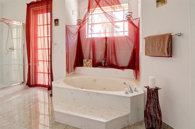 bathroom with a tub with jets and a stall shower