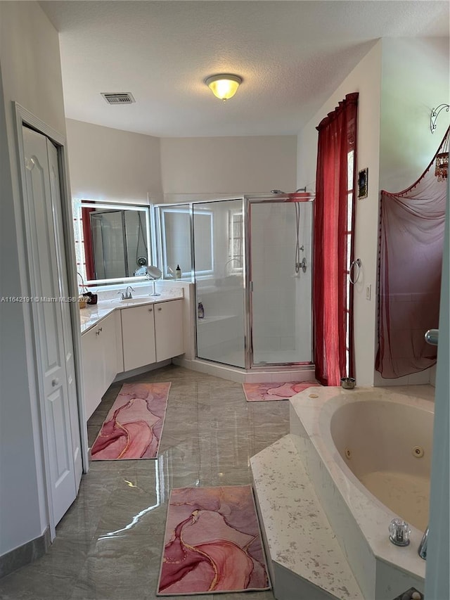 bathroom featuring vanity, a textured ceiling, a shower stall, a jetted tub, and visible vents