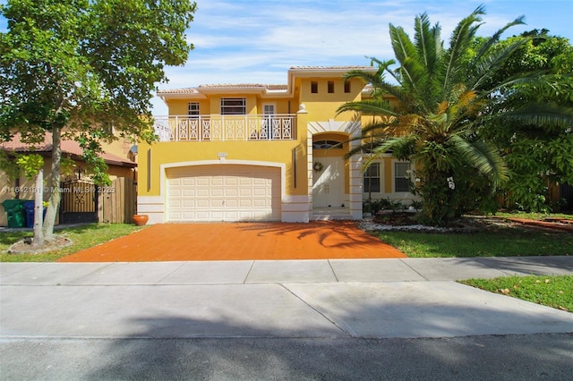 mediterranean / spanish home featuring a balcony, a garage, driveway, a gate, and stucco siding