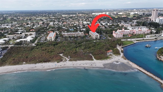 drone / aerial view featuring a water view and a view of the beach