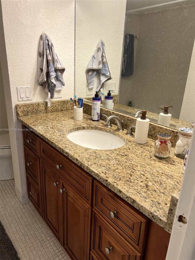 bathroom with tile patterned floors, vanity, and toilet