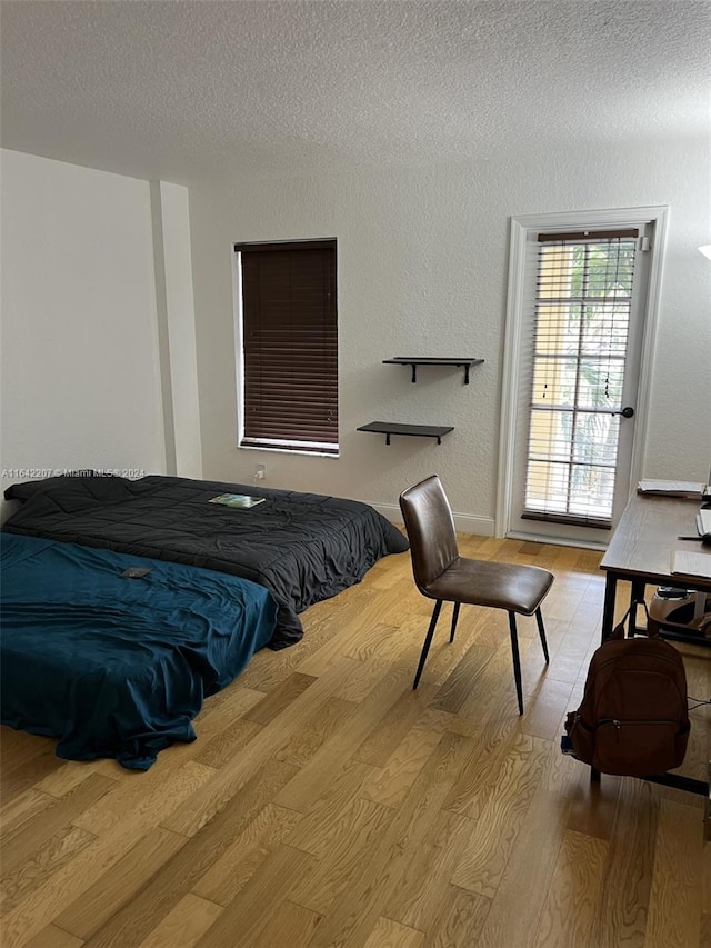 bedroom with light hardwood / wood-style flooring and a textured ceiling