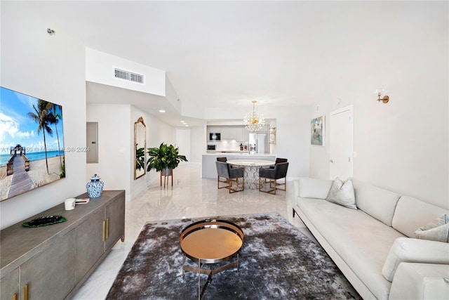 tiled living room featuring electric panel and an inviting chandelier