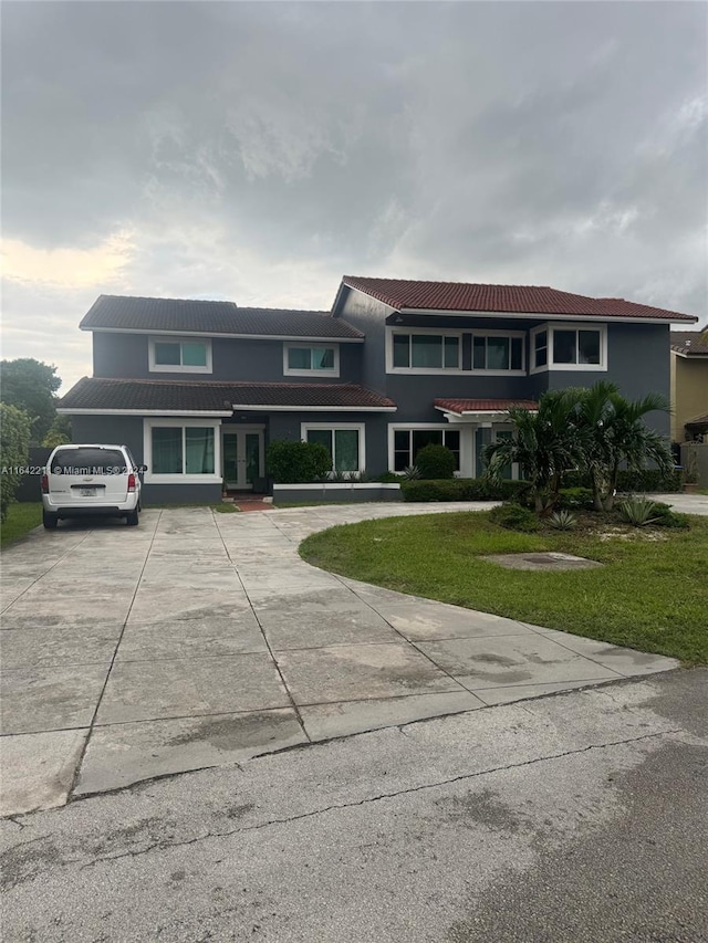 20042 W Lake Dr, Hialeah, FL 33015 - view of property with french doors, a tile roof, stucco siding, and a front lawn