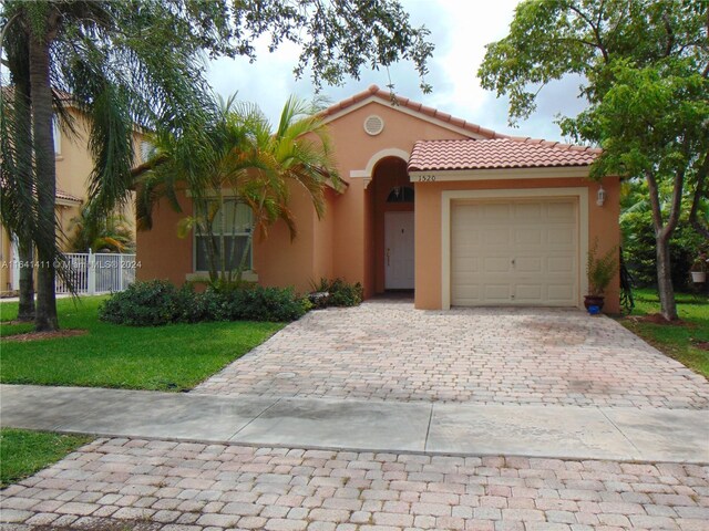 mediterranean / spanish-style house with a garage and a front yard