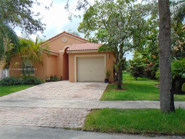 mediterranean / spanish house with a front lawn and a garage