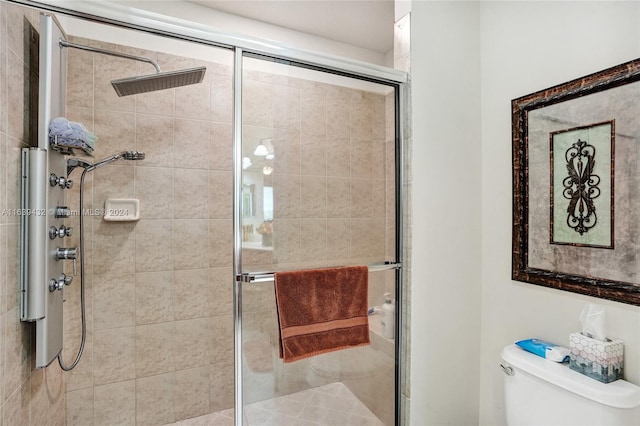 bathroom featuring a shower with shower door and toilet