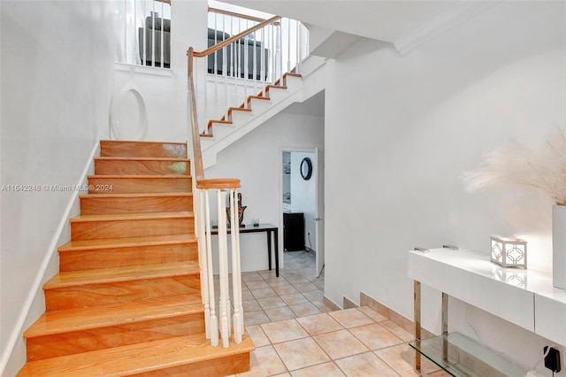 staircase featuring baseboards and tile patterned flooring