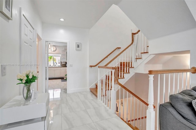 interior space with stairs, recessed lighting, baseboards, and a sink