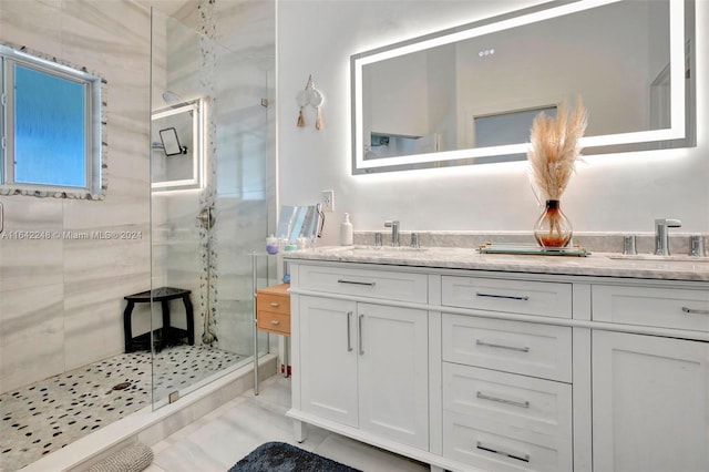 full bath featuring a shower stall, double vanity, and a sink