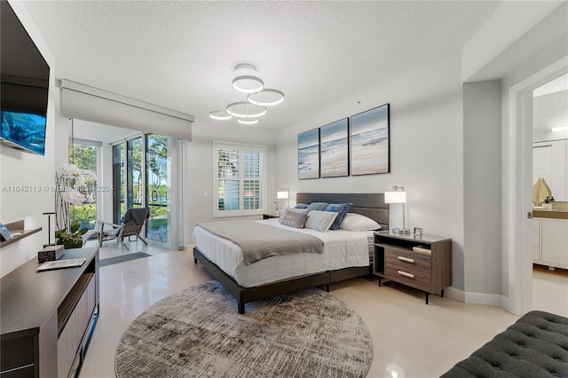 bedroom with access to exterior, a textured ceiling, and an inviting chandelier