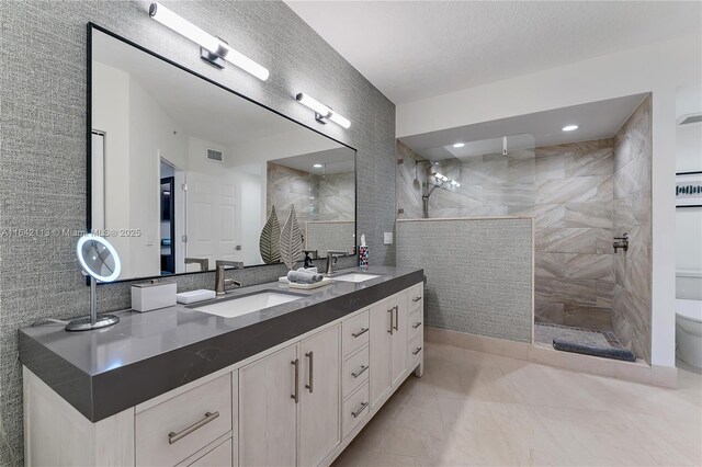 bathroom with a textured ceiling, tile walls, toilet, tiled shower, and vanity