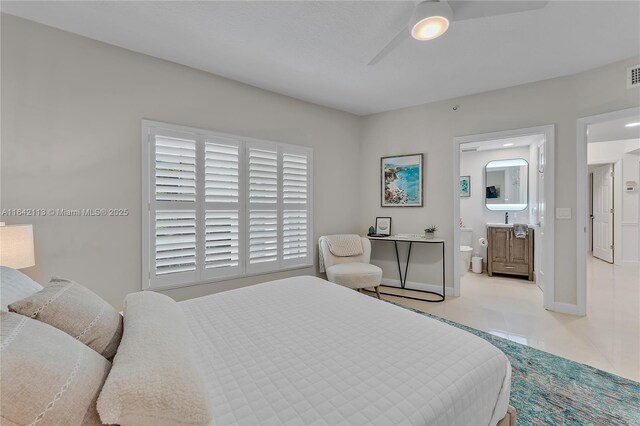 bedroom featuring ensuite bath, light tile patterned floors, and ceiling fan