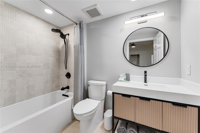 full bathroom featuring vanity, tiled shower / bath combo, and toilet