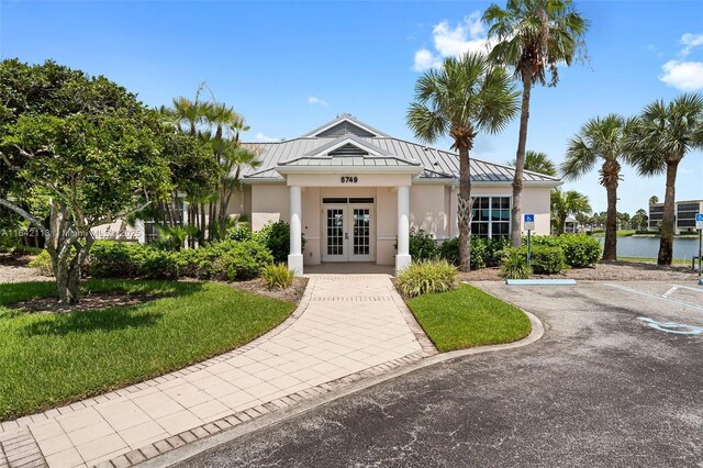 exterior space with french doors and a water view