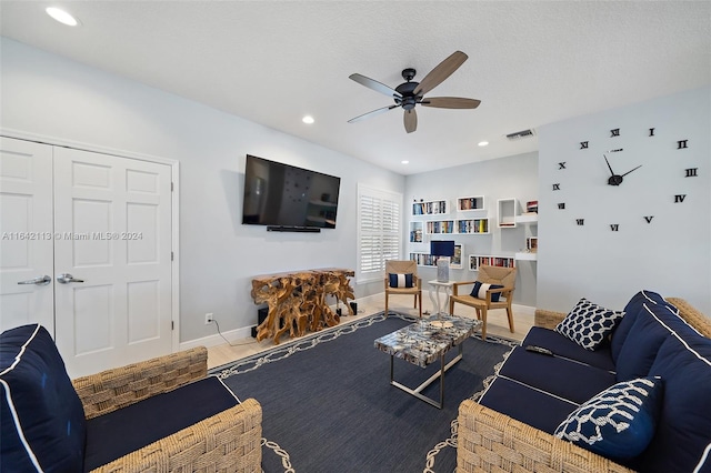 living room with a textured ceiling and ceiling fan