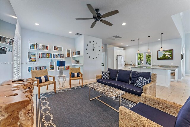 tiled living room with ceiling fan and sink