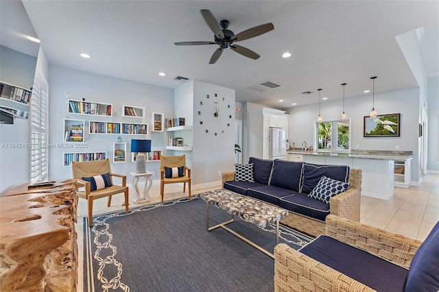 living room featuring sink, light tile patterned floors, and ceiling fan