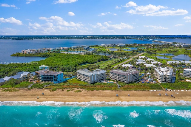 birds eye view of property featuring a water view and a beach view