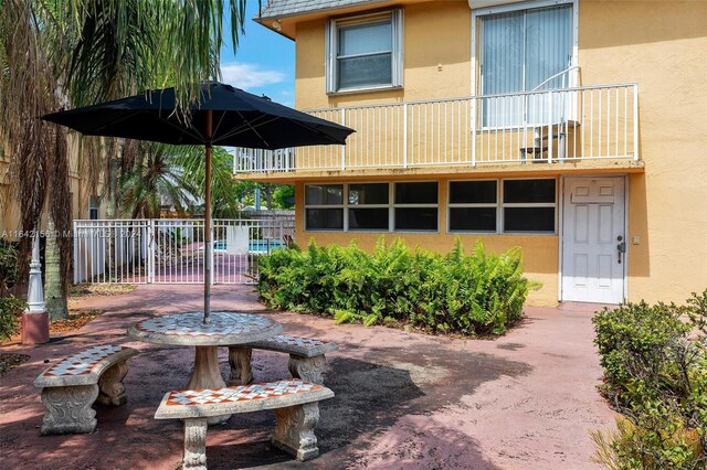 rear view of house featuring a balcony and a patio