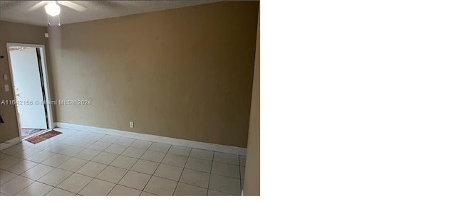 spare room with a textured ceiling and baseboards