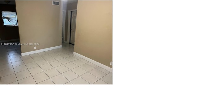 empty room featuring baseboards, visible vents, and light tile patterned flooring