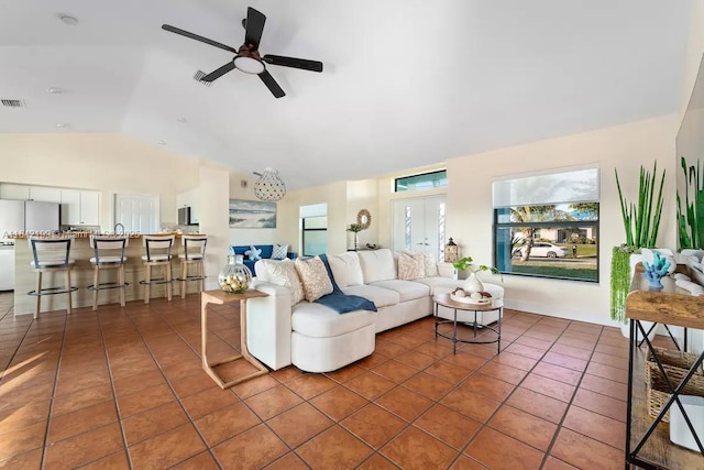 tiled living room featuring ceiling fan and vaulted ceiling