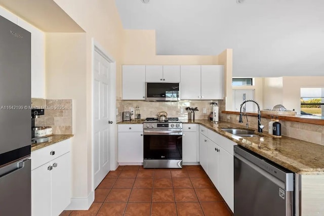 kitchen featuring white cabinetry, stainless steel appliances, sink, kitchen peninsula, and stone counters