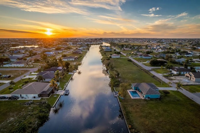 aerial view at dusk featuring a water view