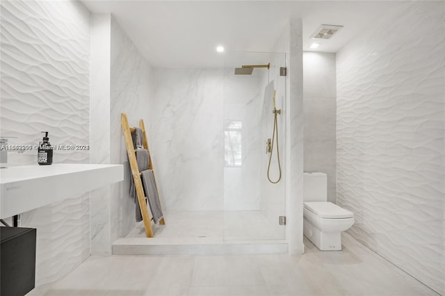 bathroom with tile walls, toilet, tile patterned floors, and a tile shower