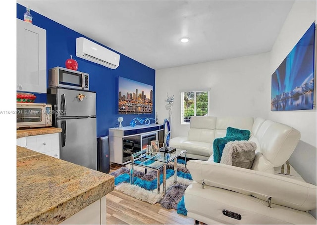 living room featuring light wood-type flooring and a wall mounted air conditioner