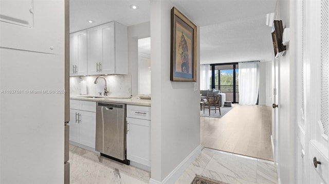 bar with backsplash, baseboards, dishwasher, marble finish floor, and a sink