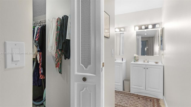 full bathroom with vanity and a spacious closet