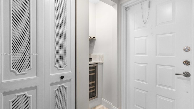 bathroom featuring baseboards and wine cooler