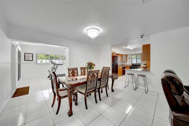 tiled dining space with a chandelier