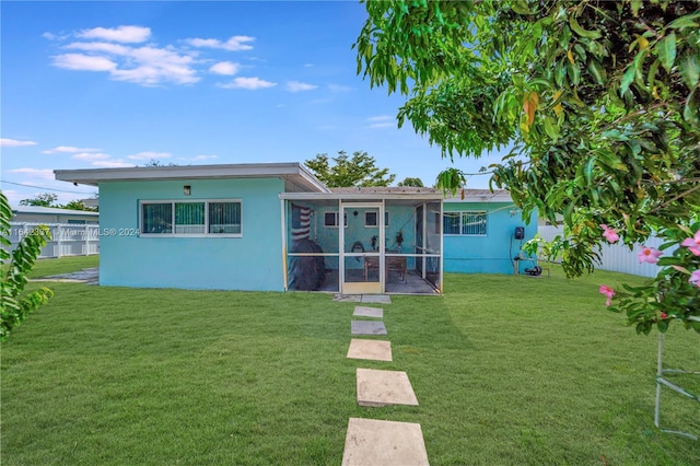 back of house with a sunroom and a yard