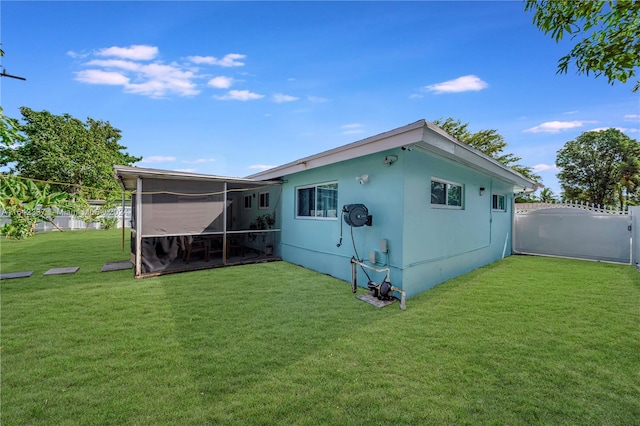 back of house with a yard and a sunroom