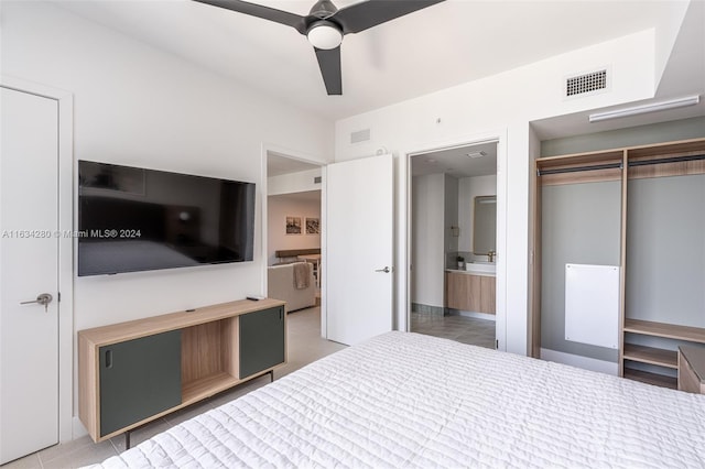 unfurnished bedroom with tile patterned floors, a closet, ceiling fan, and ensuite bath